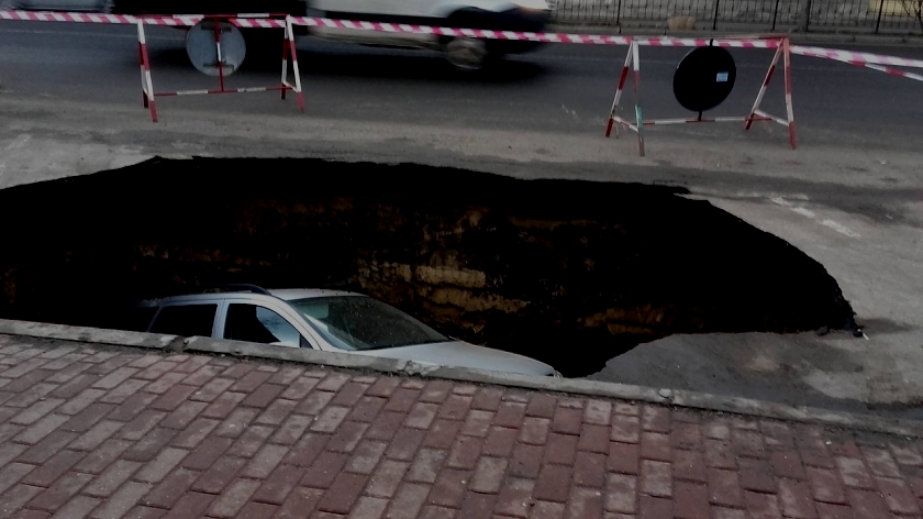 Autoturism ‘înghiţit’ de un crater într-o parcare pe DN 2. Traficul a fost deviat