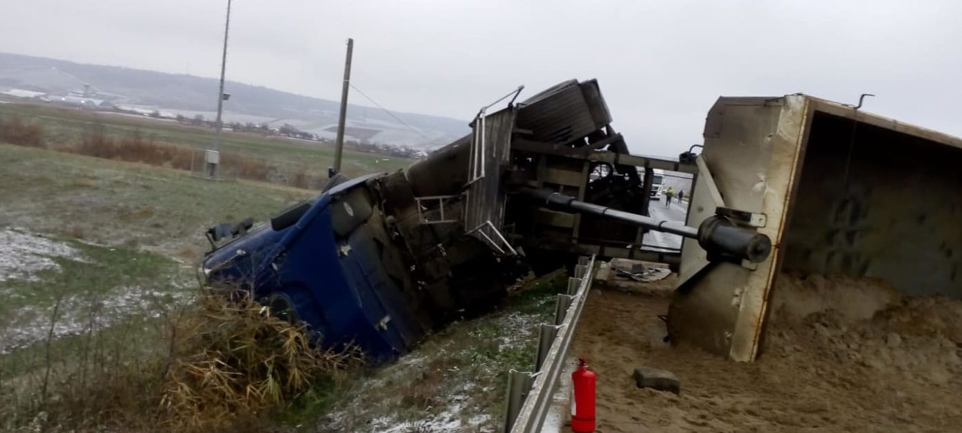 (AUDIO/FOTO) Vaslui: Un autocamion cu nisip s-a răsturnat pe DE 581. Circulaţia rutieră se desfăşoară pe un singur fir