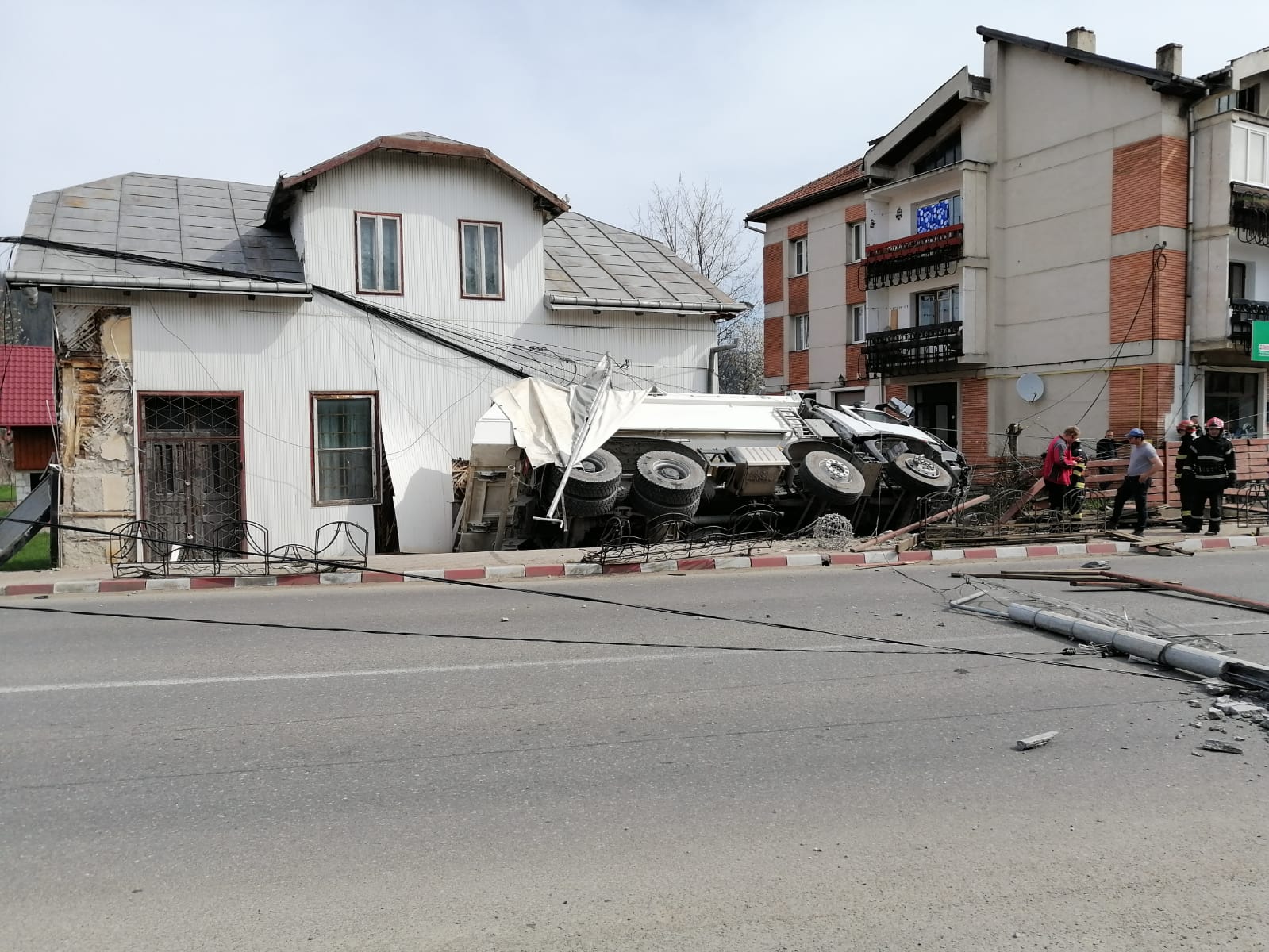 (FOTO) Autobasculantă încărcată cu pietriş s-a oprit în peretele unei case în loc. Frasin